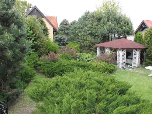 a garden with a gazebo and bushes at Holiday Home Letniskowa 29 by Interhome in Ogonki