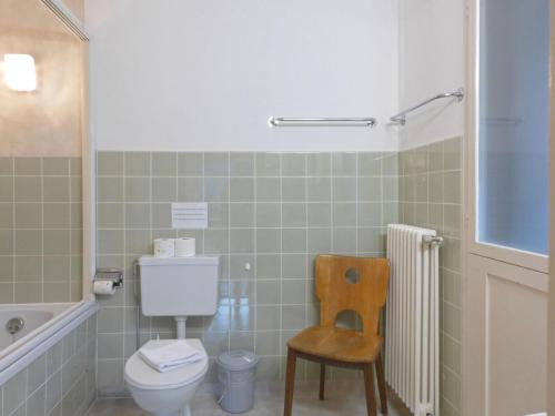 a bathroom with a toilet and a chair and a tub at Apartment Helene Apt-Diana by Interhome in Wengen