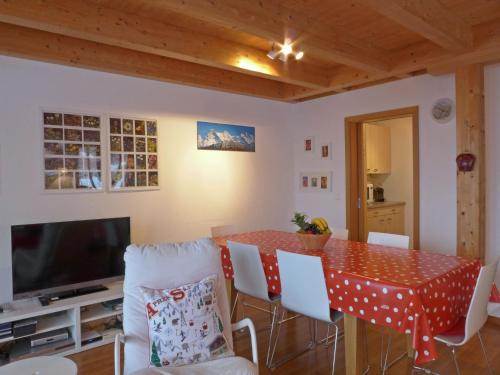 una sala da pranzo con tavolo e TV di Apartment Racer's Retreat-2 by Interhome a Wengen