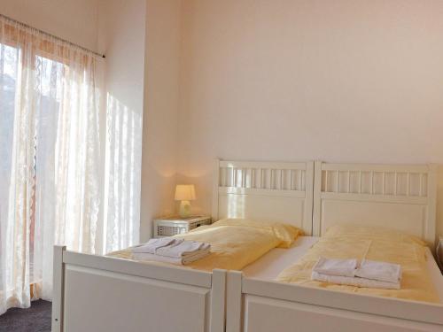a white bed with two towels on it in a bedroom at Apartment Racer's Retreat Apt-12 by Interhome in Wengen