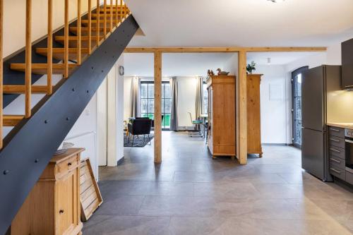 a kitchen with a staircase and a living room at Landhaus 1884 OFC 17 in Beiershagen