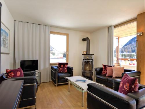 sala de estar con muebles de cuero y chimenea en Apartment Chesa Lej by Interhome, en Pontresina