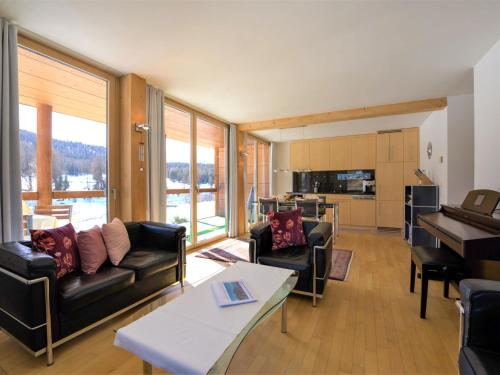 a living room with a couch and a table and a kitchen at Apartment Chesa Lej by Interhome in Pontresina