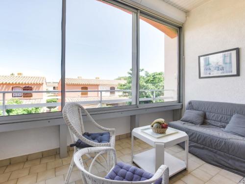 un salon avec un canapé, des chaises et une fenêtre dans l'établissement Apartment Le Florid-7 by Interhome, au Cap d'Agde