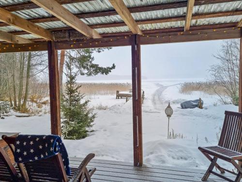 a screened porch with a view of a snow covered yard at Holiday Home Willa klaara by Interhome in Patajoki