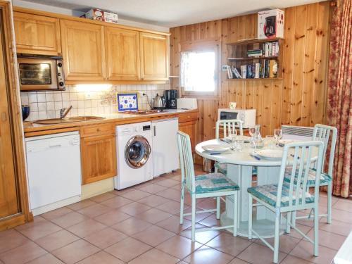 une cuisine avec une table et des chaises ainsi qu'un lave-linge dans l'établissement Apartment Jardins Alpins 4 by Interhome, à Saint-Gervais-les-Bains