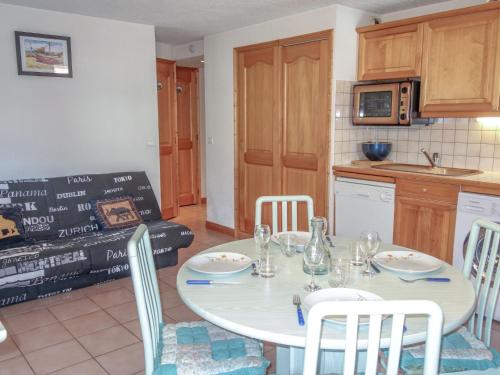 une cuisine et une salle à manger avec une table et des chaises blanches dans l'établissement Apartment Jardins Alpins 4 by Interhome, à Saint-Gervais-les-Bains