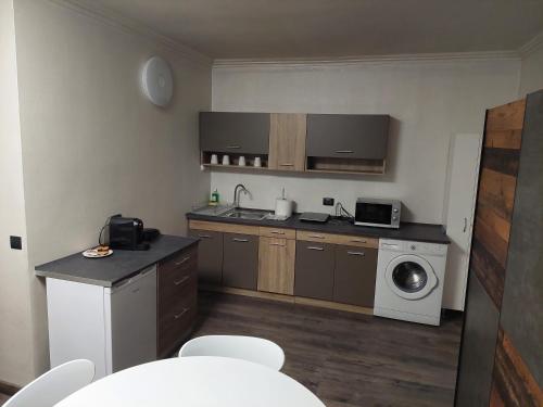 a small kitchen with a washing machine and a washer at Apartment First December in Oradea