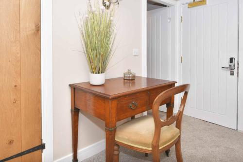 a wooden table with a chair and a plant on it at The Royal Oak in Biddulph