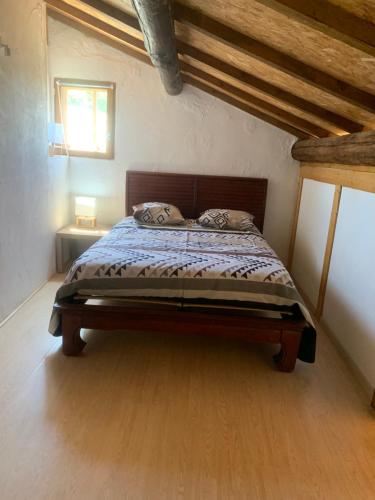 une chambre avec un lit avec une tête de lit en bois dans l'établissement Douceur de Vignes, à Servian