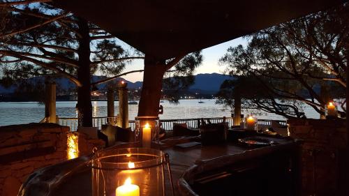 a table with candles on it with a view of the water at Hôtel Le Belvédère in Porto-Vecchio