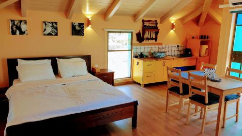 a bedroom with a bed and a table and a kitchen at Andalusian House in the Gilboa in Gid‘ona