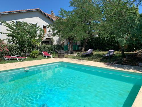 une grande piscine devant une maison dans l'établissement Douceur de Vignes, à Servian
