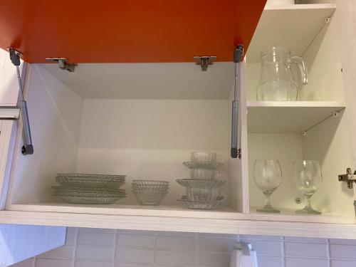 une armoire remplie de bols et de verres en verre dans l'établissement SeuLar o conforto de um Lar em Qualquer Lugar, à São Paulo