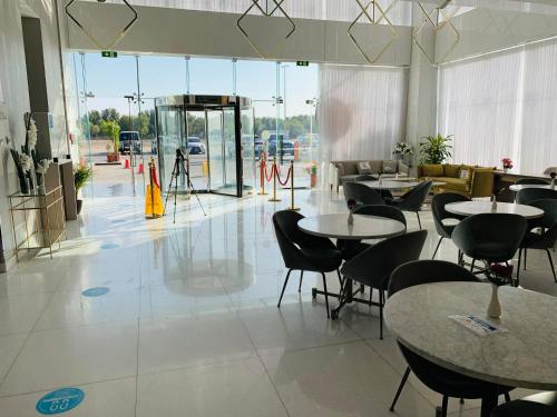 a restaurant with tables and chairs in a room at Saray Deluxe Hotel Apartments in Abu Dhabi