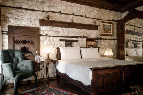 a bedroom with a bed and a stone wall at Hani i Xheblatit in Berat
