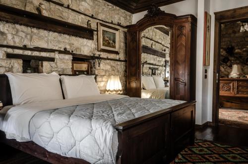 a bedroom with a bed and a stone wall at Hani i Xheblatit in Berat