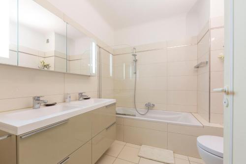 une salle de bain avec un lavabo, une baignoire et des toilettes dans l'établissement Appartement entièrement équipé de 105 m2 avec vue mer et collines, à Cannes