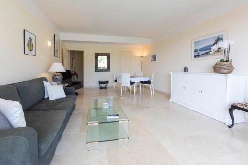 un salon avec un canapé et une table en verre dans l'établissement Appartement entièrement équipé de 105 m2 avec vue mer et collines, à Cannes