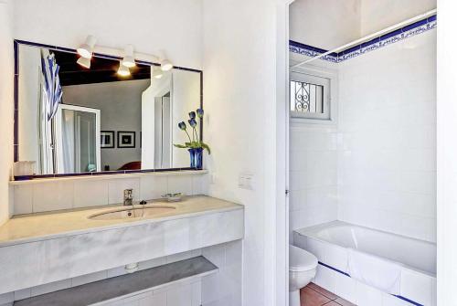 a white bathroom with a sink and a mirror at Sonrisa Binibeca Menorca in Binibeca