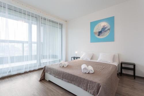 1 dormitorio con 1 cama con 2 toallas en Yellow apartment with PARKING, en Praga