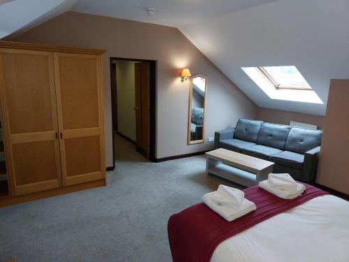 a bedroom with a bed and a couch in a room at County Lodge & Brasserie in Carnforth