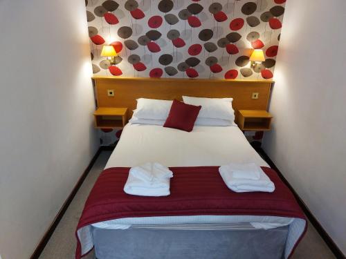 a bedroom with a bed with two towels on it at The County Lodge in Carnforth