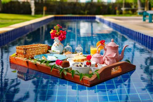 - un plateau de nourriture sur une table au bord de la piscine dans l'établissement Pousada Patacho, à Porto de Pedras