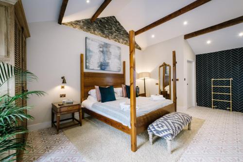 a bedroom with a four poster bed and a table at The Den - The White House Windermere in Bowness-on-Windermere