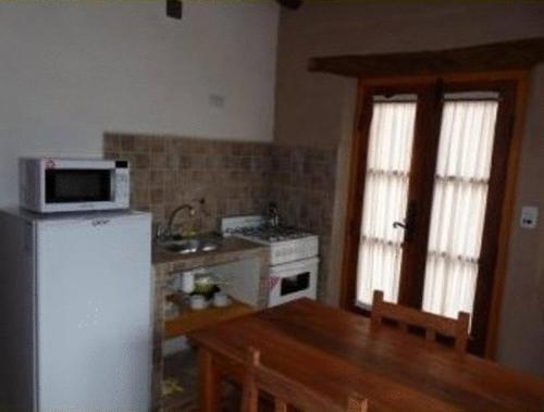 a kitchen with a white refrigerator and a microwave at Cabañas Luna y Sol in Cafayate