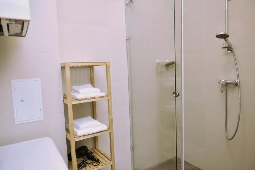 a bathroom with a shower and a shelf with towels at Jimmy's Apartments Suites in Vienna