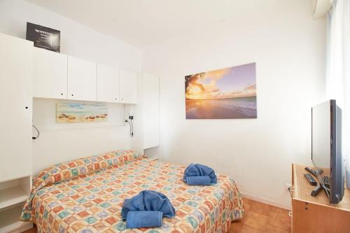 a bedroom with a bed with two blue pillows on it at Appartamenti Di Edo in Finale Ligure