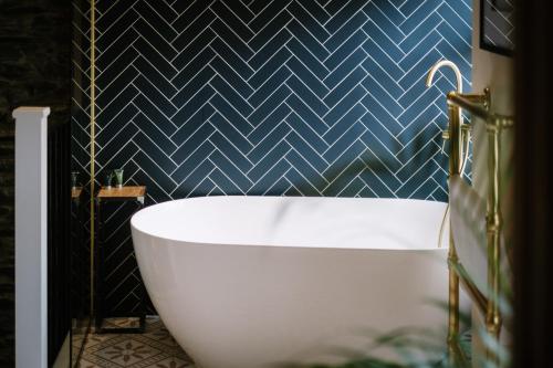 a bath tub in a bathroom with a blue wall at The Den - The White House Windermere in Bowness-on-Windermere