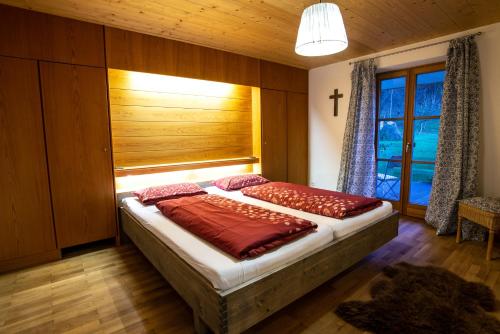 a bedroom with a large bed with a window at Haus Heufelder in Bad Heilbrunn