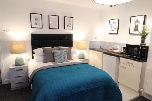 a bedroom with a bed with a blue comforter at Anson Studios Walsall M6, J10 in Walsall