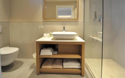 a bathroom with a sink and a toilet at Domu Simius Life Style Hotel in Villasimius