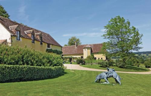a statue of a dog in the grass near a house at Stunning Home In Domfront En Champagne in Domfront-en-Champagne