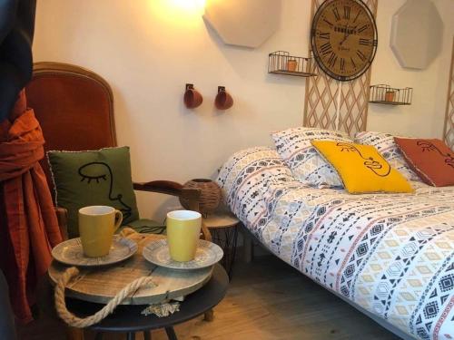 a bedroom with a bed and two tables with cups on it at Au Domaine Fresnois in Fresnes-lès-Montauban