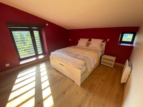 1 dormitorio con 1 cama en una habitación con paredes rojas en Gîtes Aubergine et Poivron en Toulaud