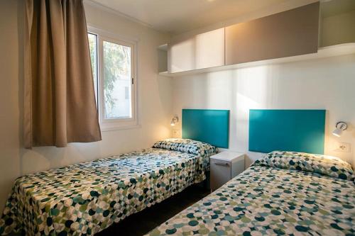 two beds in a room with two beds sidx sidx sidx at Camping Europa in Capoliveri