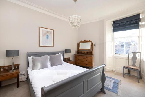 a bedroom with a bed and a dresser and a mirror at ALTIDO Old Town 1-Bed Apartment with Stunning Views in Edinburgh