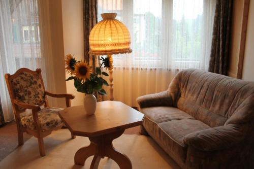 a living room with a couch and a table and a lamp at Gemeinschaftshaus im Oberdorf in Lützelflüh