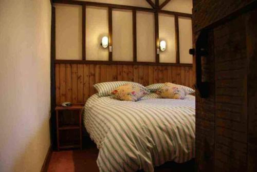 Un dormitorio con una cama con almohadas. en The Stable, en Hailsham