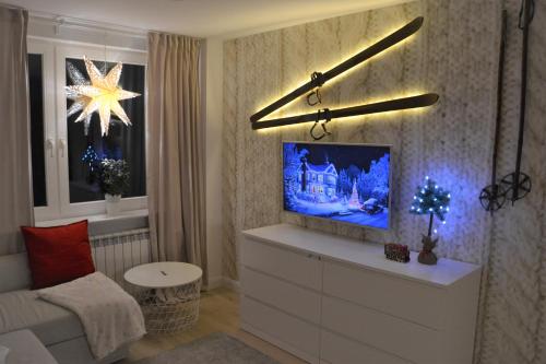 salon z telewizorem na górze komody w obiekcie Apartament przy Pijalni w mieście Krynica Zdrój