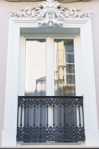 a window with a black railing on a building at Lumen Place APARTAMENTOS in Mondoñedo