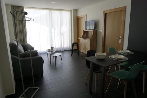 a living room with a couch and a table at Lumen Place APARTAMENTOS in Mondoñedo