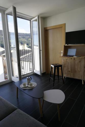 a room with a couch and a table and a television at Lumen Place APARTAMENTOS in Mondoñedo