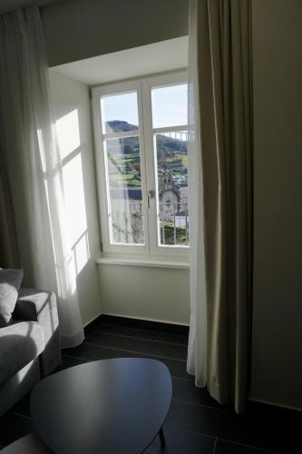 a living room with a couch and a table and a window at Lumen Place APARTAMENTOS in Mondoñedo