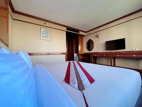 een slaapkamer met een bed en een tv aan de muur bij The Promenade Hotel - SHA Plus in Bangkok