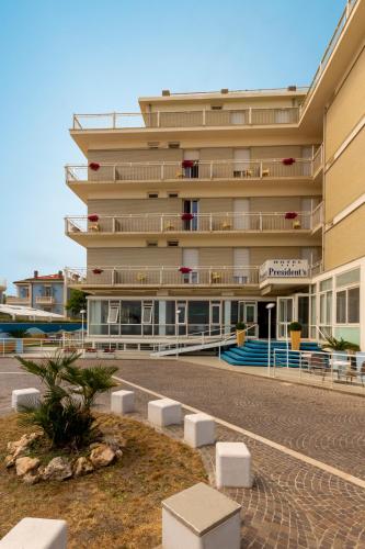 a large building with balconies on the side of it at Hotel President's in Pesaro